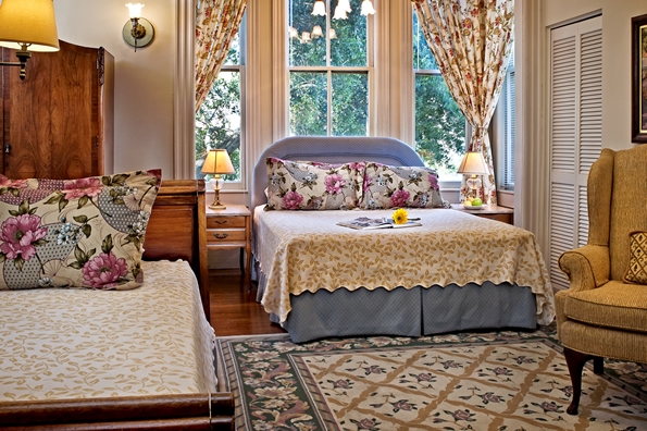 Queen sized bed by window box.  Twin Sleigh bed in Foreground.  with Antique furniture and design