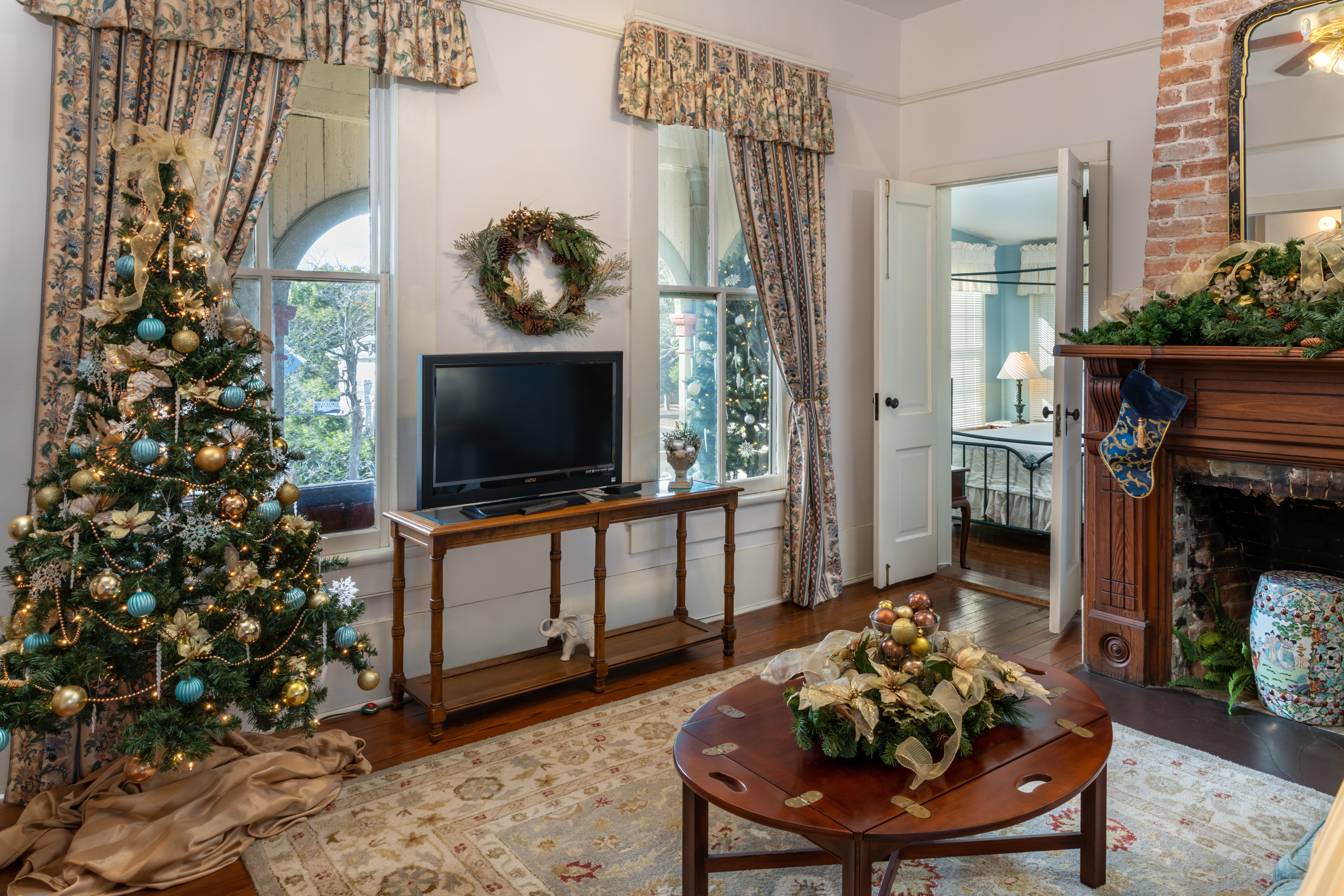 Festively decorated guest suite with Christmas tree and fireplace