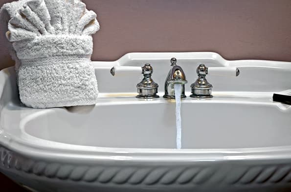 Antique looking pedestal sink with polished Chrome and porcelain fixtures.