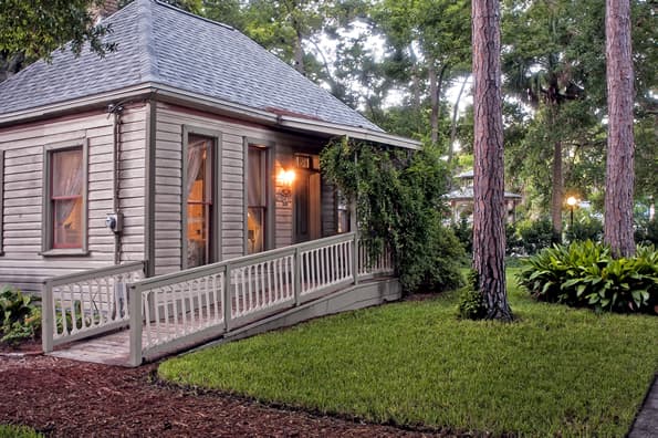 Gentle sloping ramp leading to ivy covered overhang at entry of cottage.