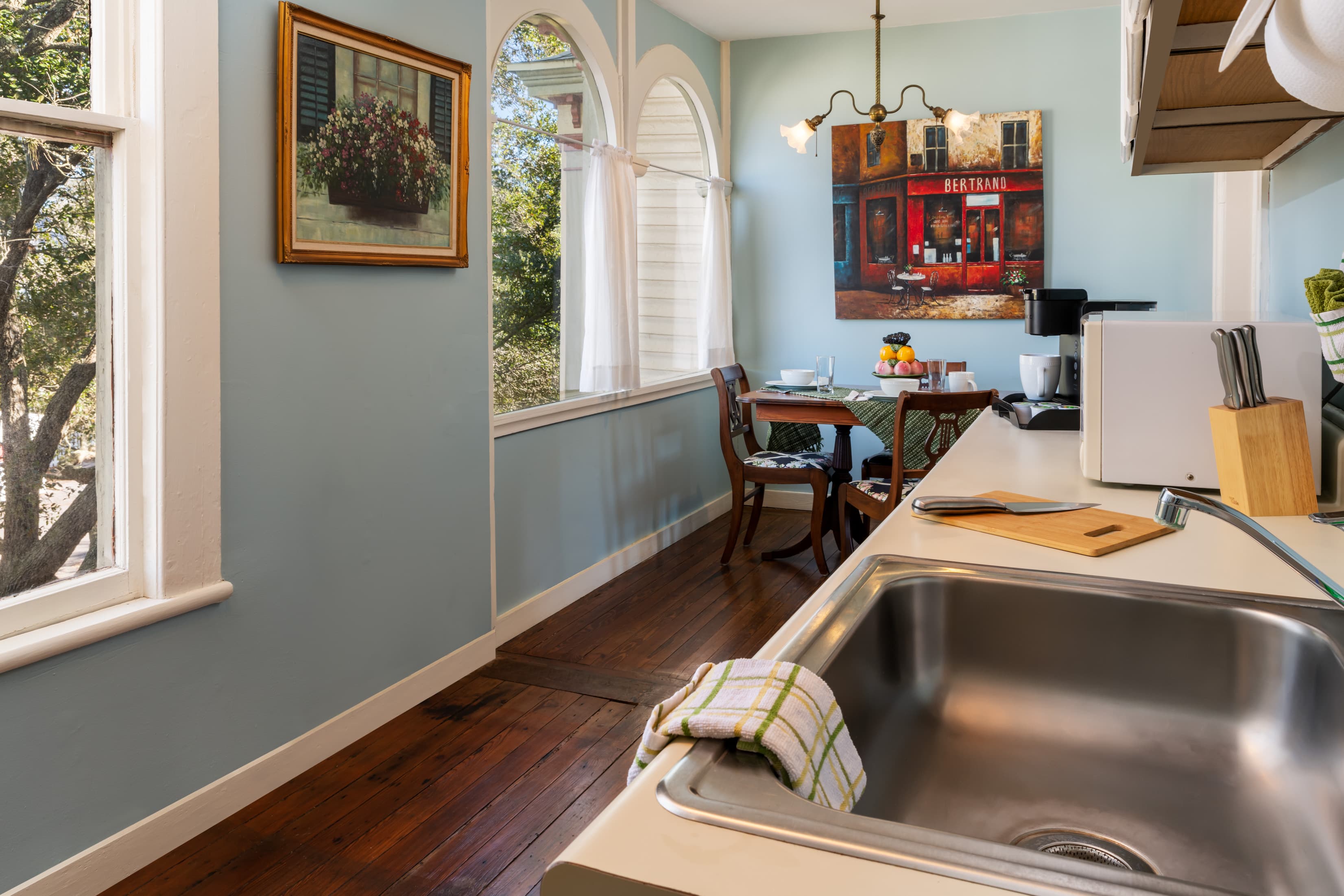 Guest suite kitchenette and dining area with arched windows and hardwood floors