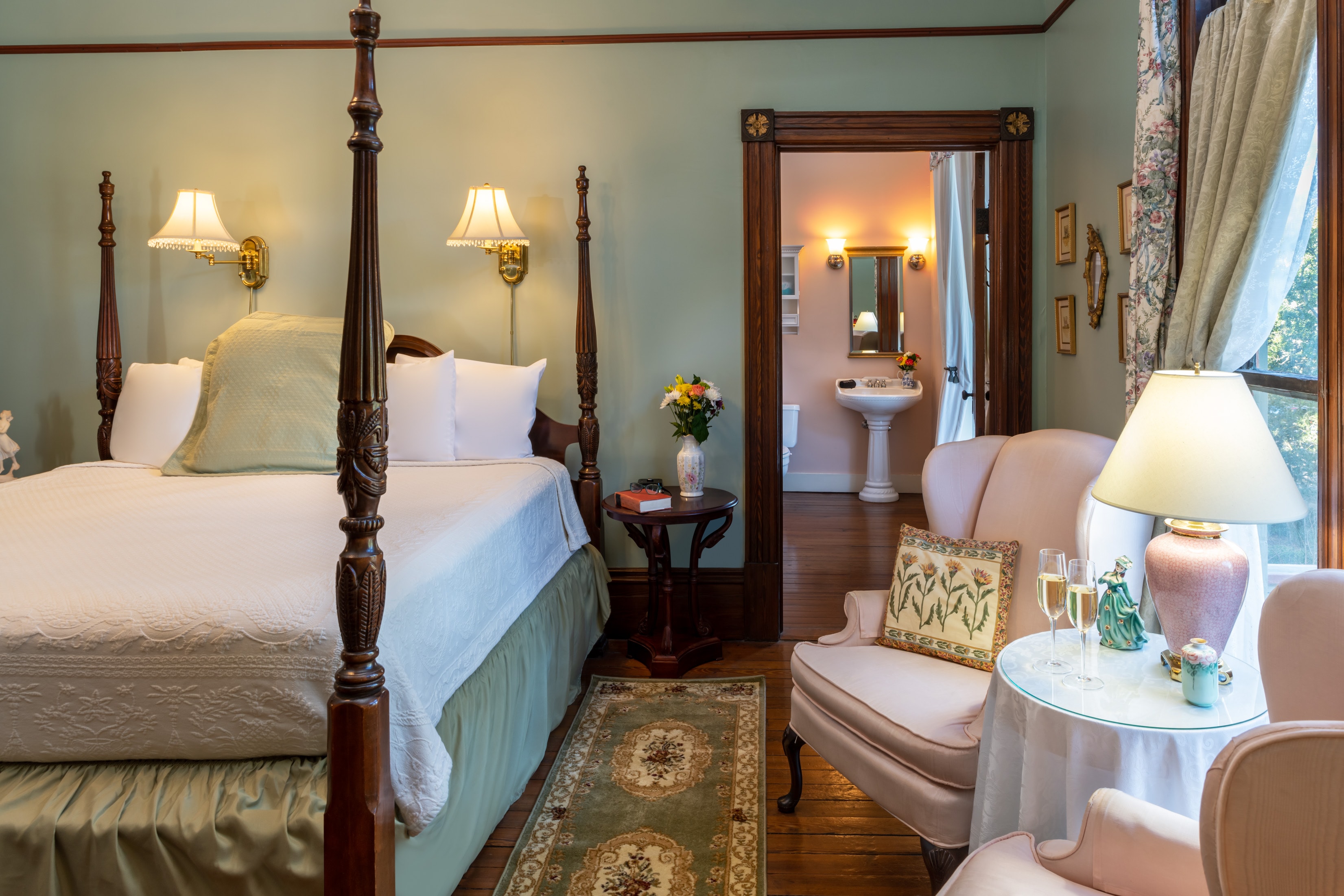 Elegant guest room with four-poster bed and cozy sitting area