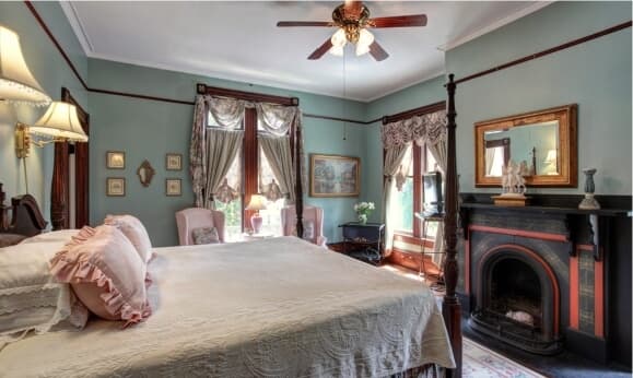 A cozy bedroom with a bed, elegant decor, and a fireplace.