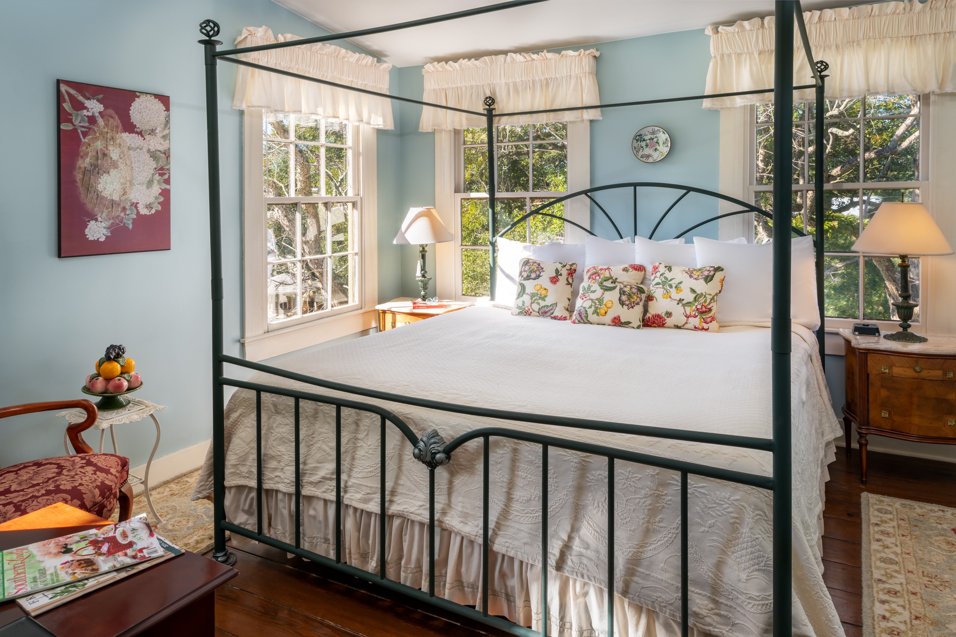 Bright guest bedroom with four-poster bed and large windows