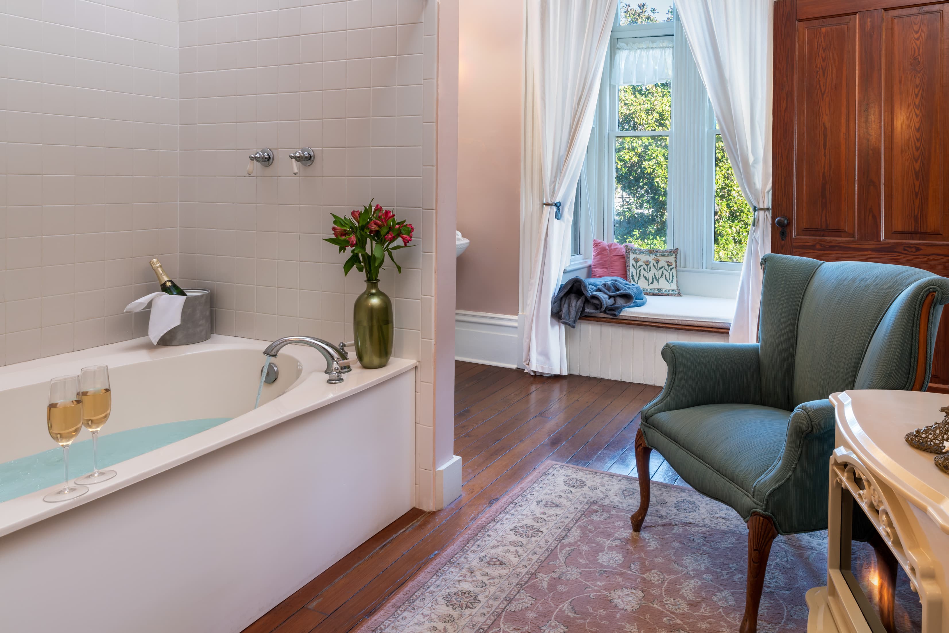 Spacious soaking tub and sitting area with garden views