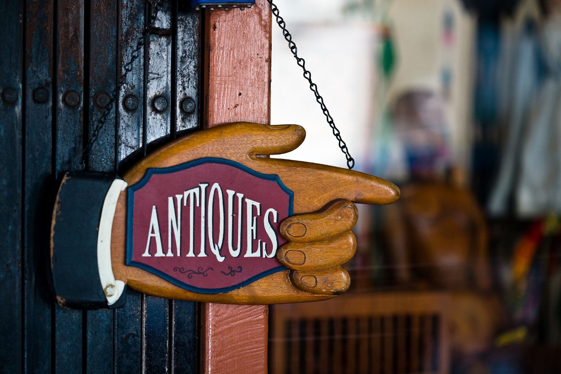 A wooden sign shaped like a hand points to the word "Antiques."