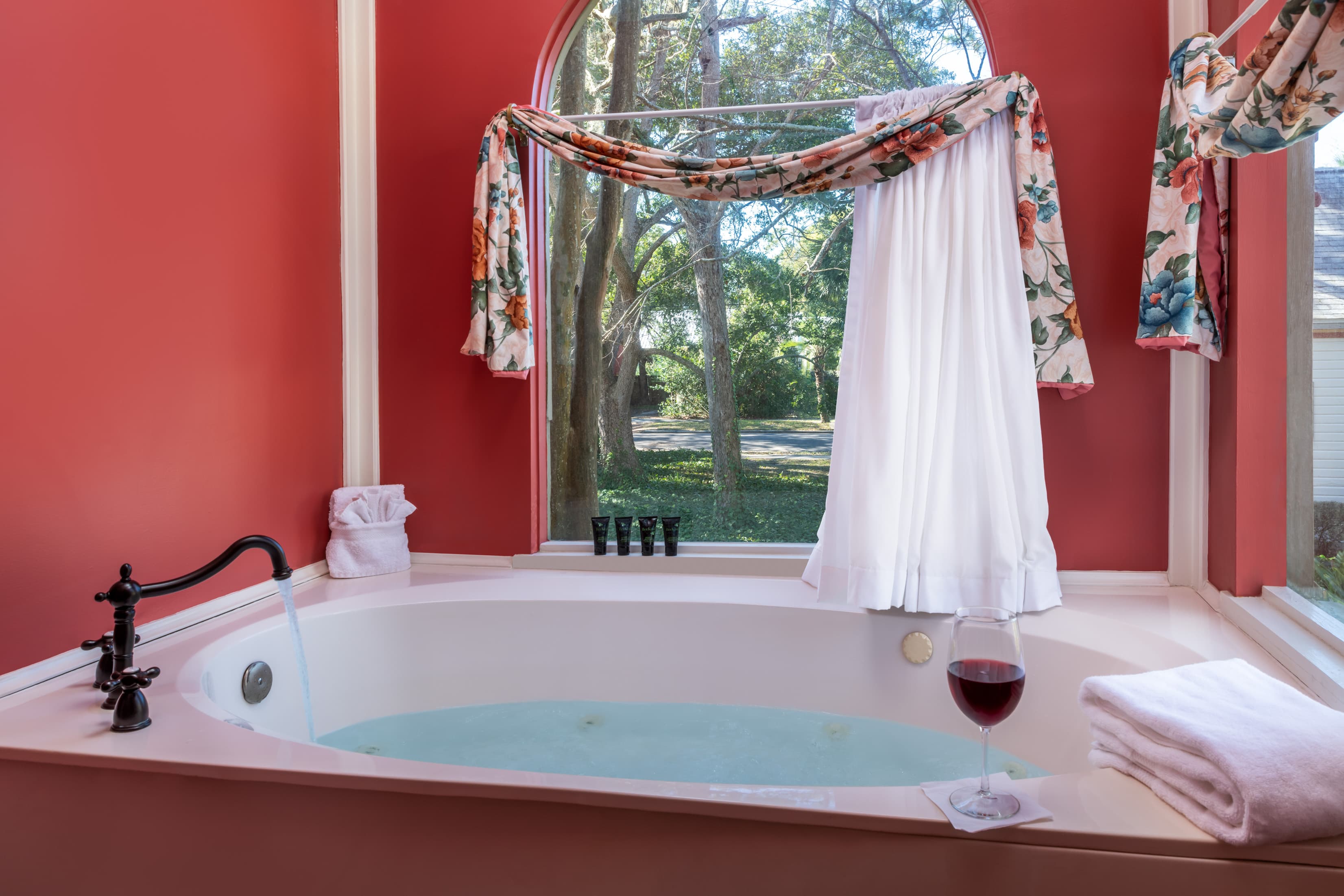 Spacious soaking tub with garden views and floral accents inside a guest suite