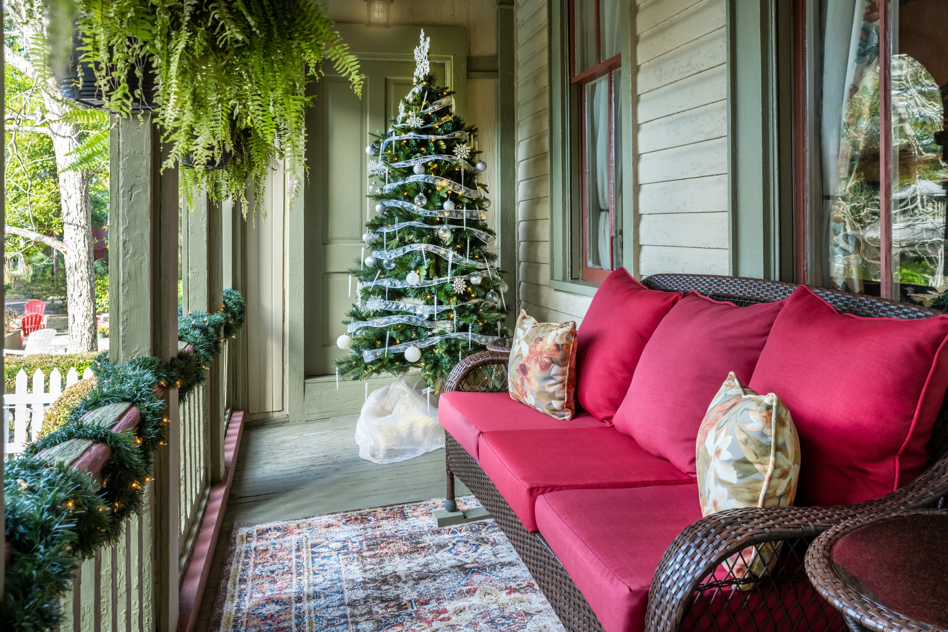 Festive holiday porch décor with cozy seating and Christmas tree