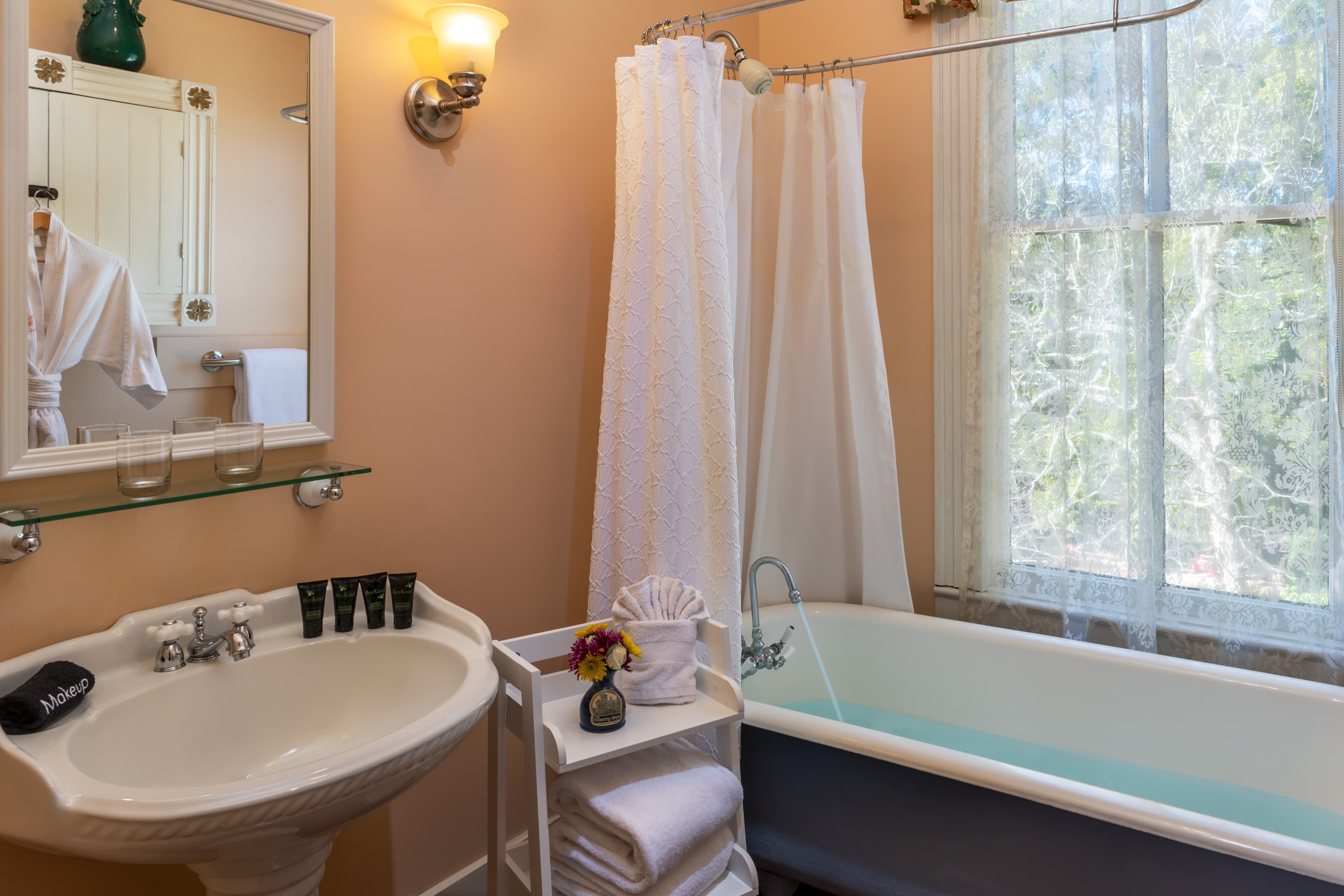 Bright guest bathroom with clawfoot soaking tub and large window