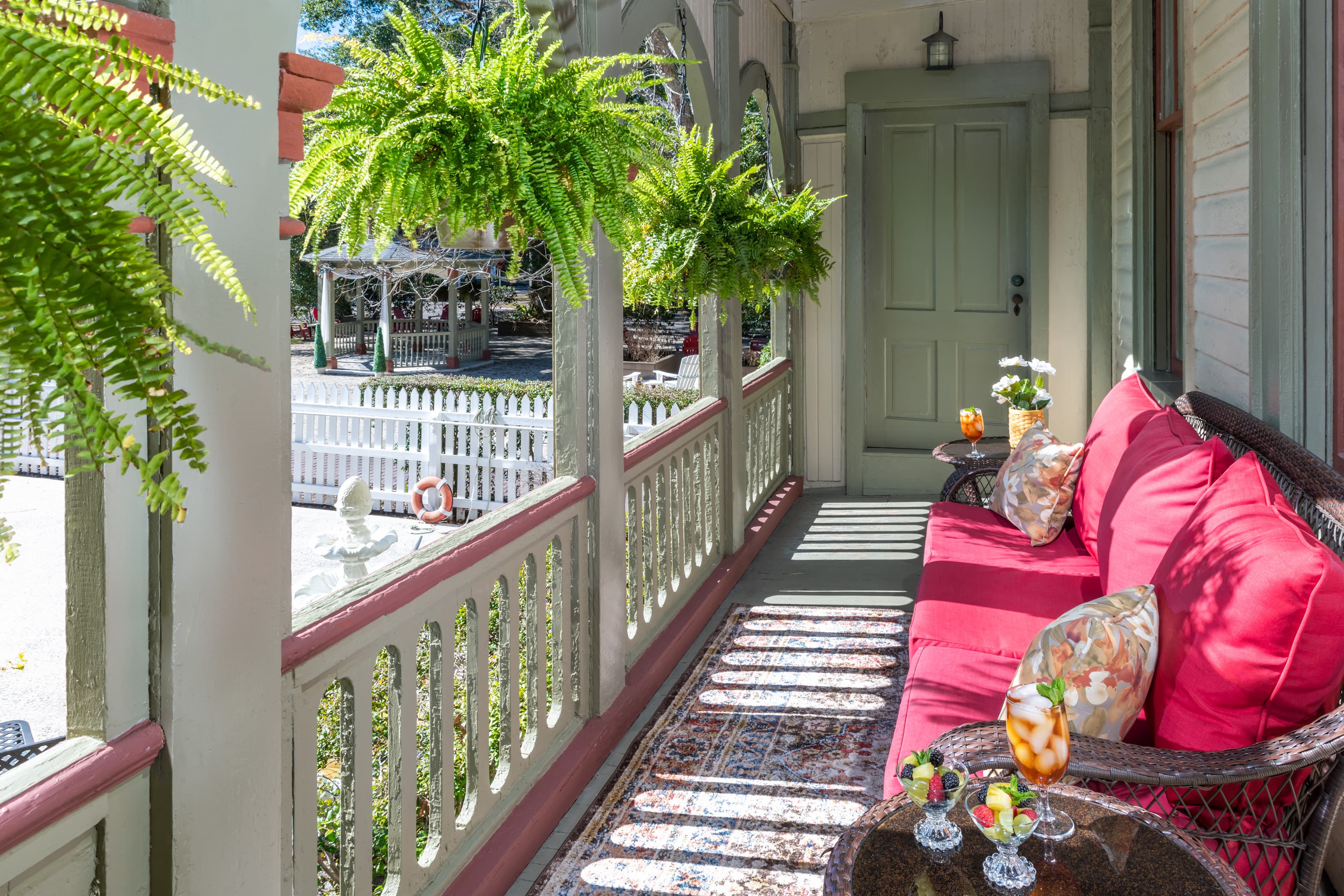Charming wraparound porch with cushioned seating and refreshing drinks
