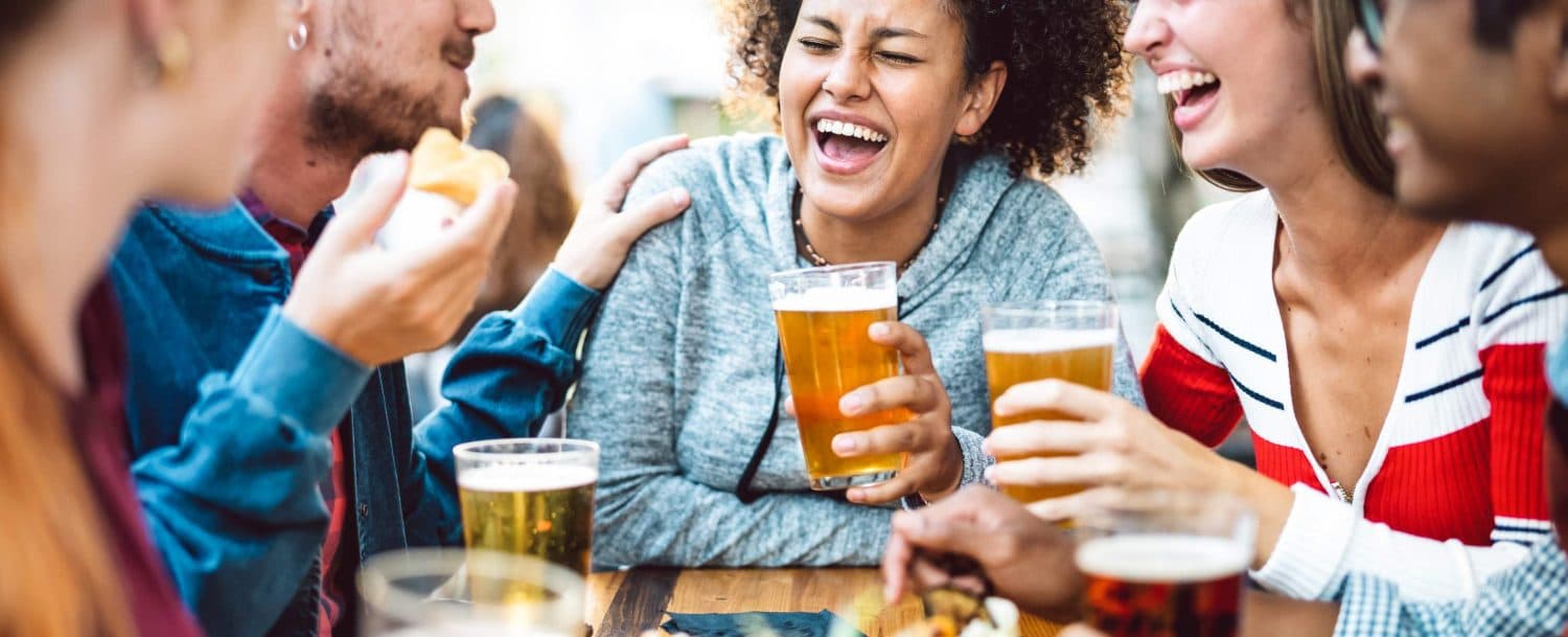 A group of friends enjoys drinks and laughter at a social gathering.