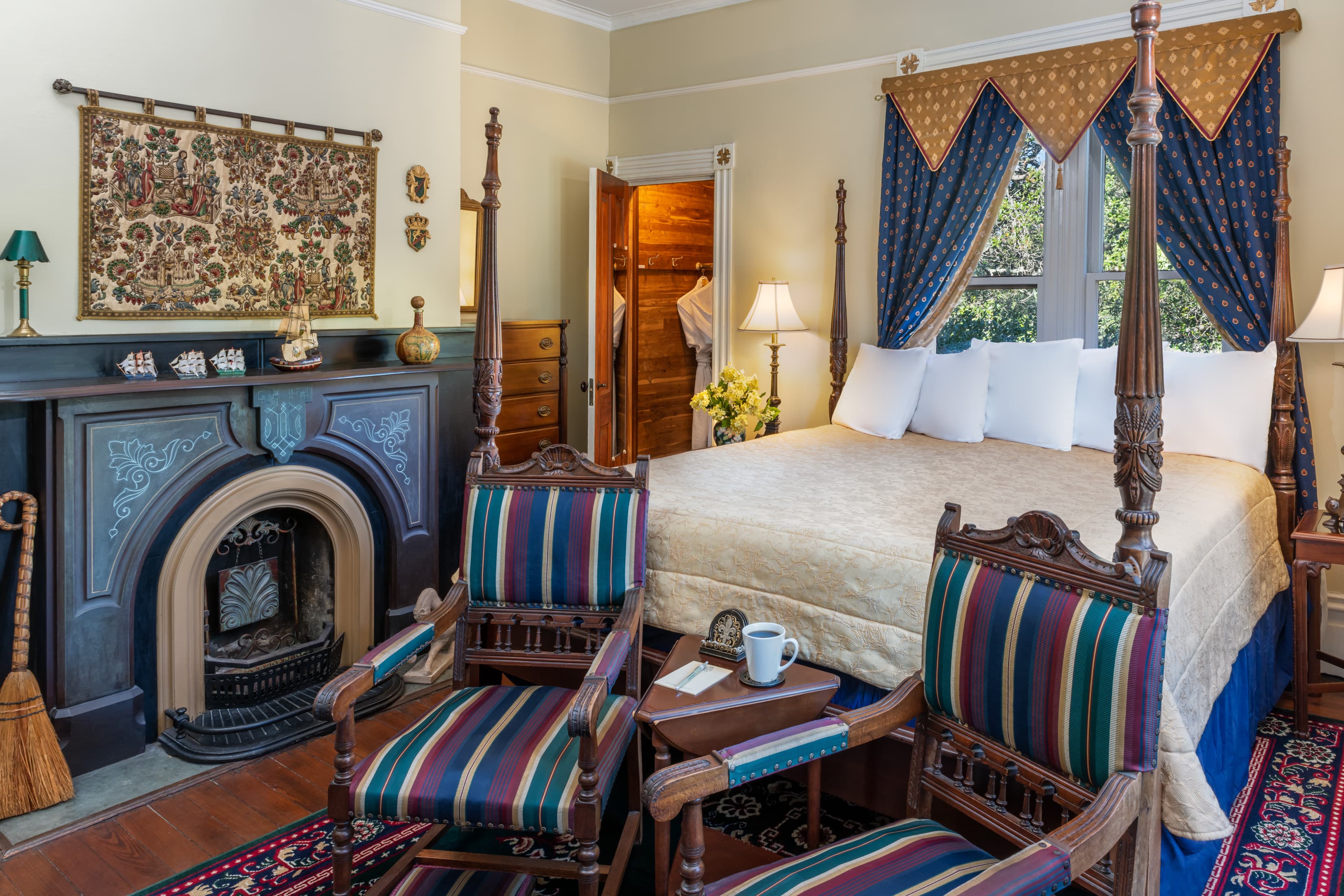 Historic guest suite with four-poster bed, decorative fireplace, and vintage furnishings