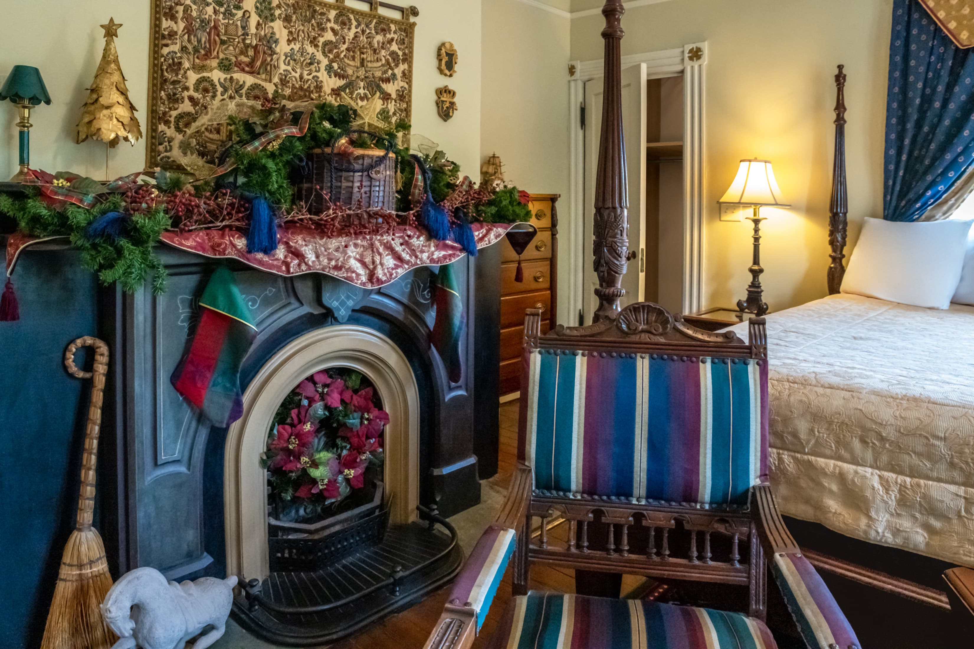 Festively decorated guest room with holiday garland, fireplace, and elegant seating