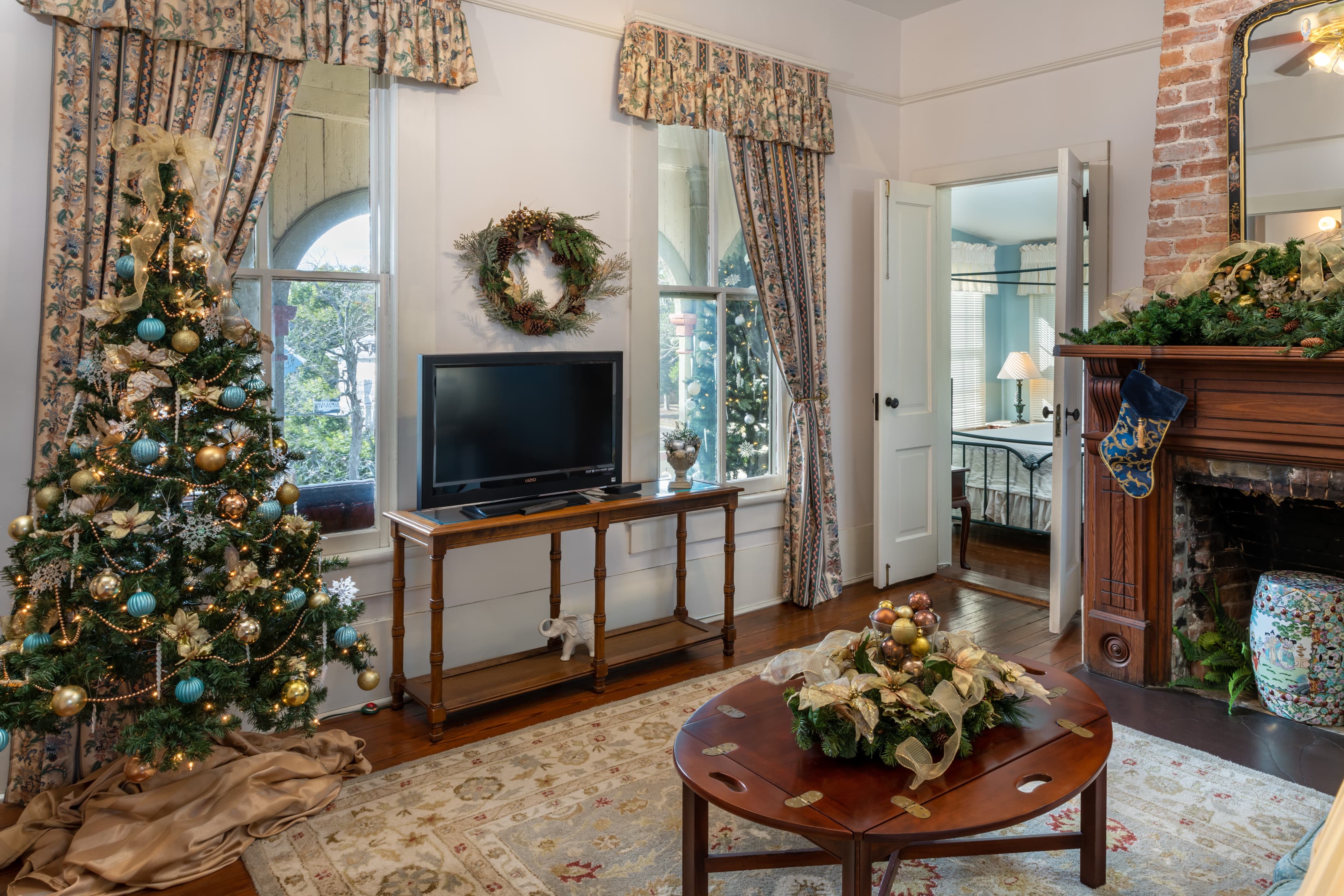 Festively decorated guest suite with Christmas tree and fireplace
