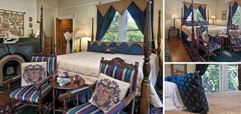 The guest room with a four poster bed, patterned chairs, dark blue curtains, and classic decor arranged in a cozy historic inn setting.